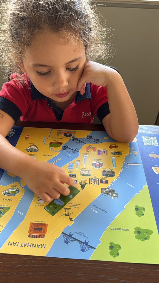 Child using New York City map placemat for kids featuring NYC landmarks
